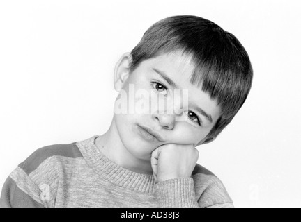 Photo en noir et blanc d'un jeune garçon à la triste. Banque D'Images