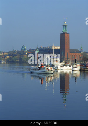 Hôtel de ville qui se reflète sur les eaux Riddarfjarden avec partent à Stockholm Banque D'Images