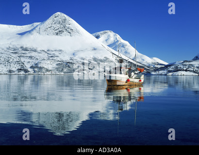 Bateau de pêche et qui se reflète sur les montagnes dans le Nord de la Norvège Fjord Morsvikbotn Banque D'Images