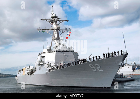 Les marins stationnés à bord du destroyer lance-missiles USS Momsen homme les rails à mesure que le navire s'éloigne de l'embarcadère. Banque D'Images