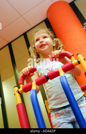 4 ans, fille, à un centre de loisirs à l'aide de fonctionnement de la machine en creche, Brixton, London UK. Banque D'Images
