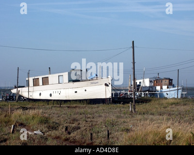 West Mersea bateaux maison reposant sur des vasières sur la rive du canal B-6673 près de l'estuaire de la rivière Blackwater Banque D'Images