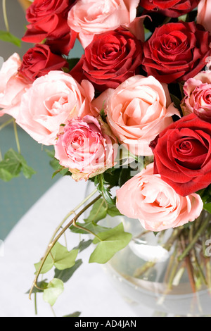 Un bouquet de roses rouges et roses dans un vase sur une table Banque D'Images