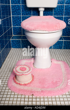 Des toilettes avec fluffy housse de siège et tapis rose Banque D'Images