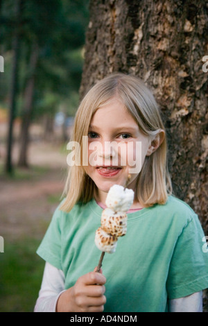 Une jeune fille manger de la guimauve grillée Banque D'Images