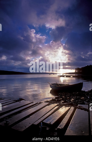 KIELDER EAU LEVER DU SOLEIL BATEAU de pêche amarré sur les rives de Kielder eau avec jetée en bois en premier plan au lever du soleil spectaculaire Kielder Northumberland Royaume-Uni Banque D'Images