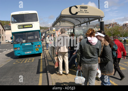 Les gens qui attendent à l'arrêt de bus à Aberystwyth avec double decker bus 550 à l'après-midi d'été ensoleillé - Cardigan Wales UK Banque D'Images