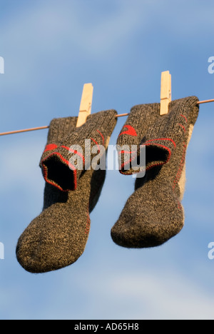 Crédit photo DOUG BLANE Concept une paire de nettoyer gris gris et rouge Chaussettes de marche en laine accroché à un fil a linge à sécher Banque D'Images