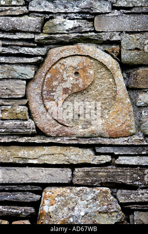 Yin Yang sculpté dans la pierre et placé au milieu d'un mur de la grange de pierres sèches sur l'île d'Orkney Banque D'Images