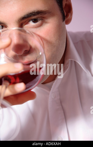 Young man drinking red wine, Close up Banque D'Images