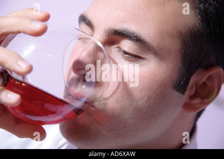 Young man drinking red wine, Close up Banque D'Images