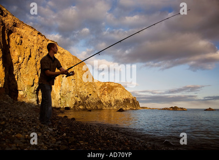 Pêche à la ligne du soir au stade Cove - site de minerai de cuivre les exportations à partir de la côte de cuivre, comté de Waterford, Irlande Banque D'Images