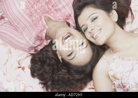 Portrait de deux jeunes femmes en position couchée et souriant Banque D'Images