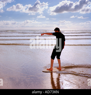 Adolescent skimboarding Woolacombe North Devon, England, UK. Banque D'Images