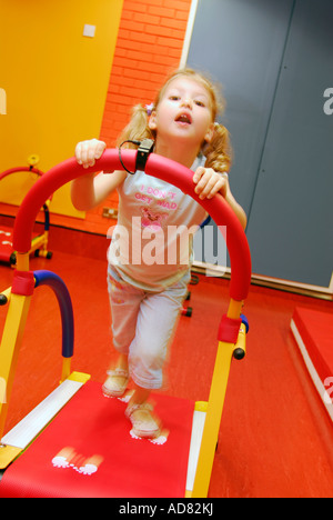 4 ans, fille, à un centre de loisirs à l'aide de fonctionnement de la machine en creche Brixton London Banque D'Images