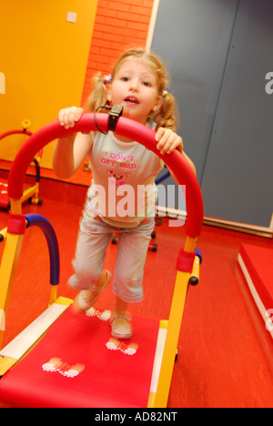 4 ans, fille, à un centre de loisirs à l'aide de fonctionnement de la machine en creche Brixton London Banque D'Images