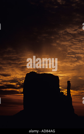 Lever de soleil sur Monument Valley avec une mitaine qui se profile avec le soleil Rayons crépusculaires traînées d'Arizona State USA Banque D'Images