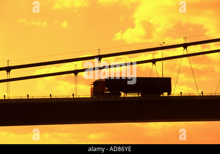 Camion roulant sur le Humber Bridge au-dessus de l'estuaire de la Humber yorkshire avec liaison coque lincolnshire près de sunset uk Banque D'Images