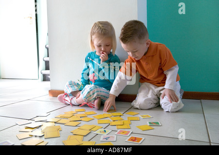 Frère et soeur jouent avec des cartes Banque D'Images