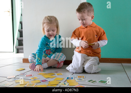 Frère et soeur jouent avec des cartes Banque D'Images