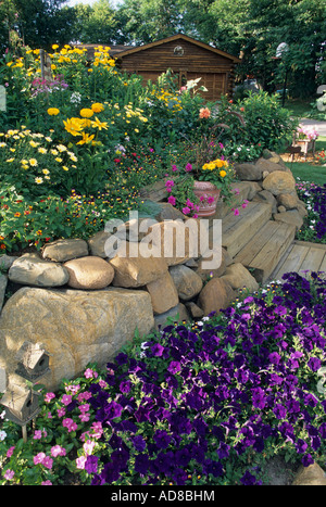 Le JARDIN D'ENTRÉE À MINNESOTA LOG HOME. VINCA, Pétunias, marguerites et SUSANS BLACK-eyed. L'été. Banque D'Images