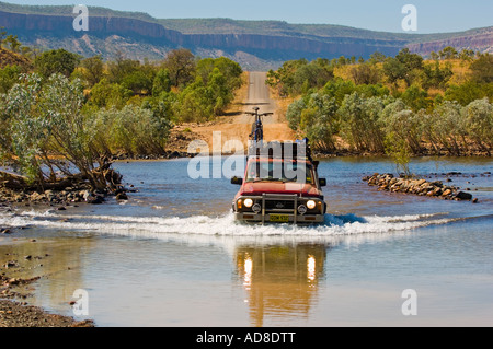 4WD à la Pentecôte River Crossing sur la Gibb River Road avec Durack de montagnes en arrière-plan l'ouest de l'Australie Banque D'Images