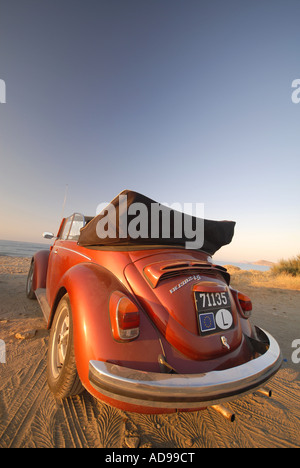 Volkswagen Beetle convertible orange sur la plage Banque D'Images