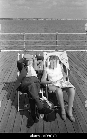 Vieux couple en vacances assis dans des transats sur la jetée. Southend on Sea Essex Angleterre 1974 1970 UK HOMER SYKES Banque D'Images