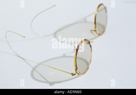 Une paire de lunettes avec lentilles circulaires et fine écaille de frames et le fil d'un grand casting d'armes ombre complexes Banque D'Images