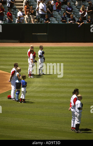 Les joueurs de baseball et les membres de la famille pour une pause lecture sur l'hymne national avant un match à Edison Field à Anaheim Califor Banque D'Images