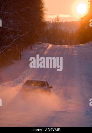 Conduite de voiture sur une route enneigée dans la soirée à l'hiver , Finlande Banque D'Images