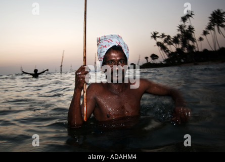 Le Weligama pêcheurs traditionnels sur pilotis dans les vagues de l'Océan Indien au large de la côte sud de l'île Banque D'Images