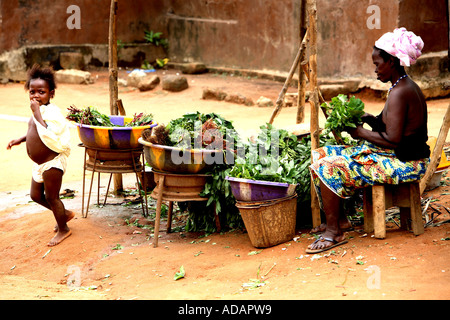 L'horizontale portrait de vieille femme au kiosque de légumes dans la rue du marché, avec bébé, Freetown, Sierra Leone Banque D'Images