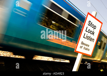 La vitesse du train par l'intermédiaire d'un passage à niveau piétonnier avec panneau d'avertissement Banque D'Images