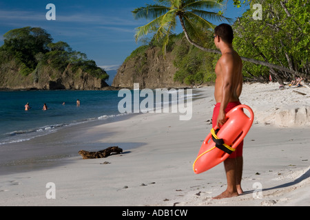 Gardien de la vie à la plage titulaire d'un dispositif de flottaison flottant Banque D'Images