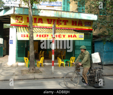 L'homme habillé en vert usure militaire passant sur une bicyclette dans les rues de Hanoï au nord du Vietnam Banque D'Images