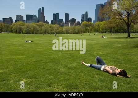 Femme couchée sur l'herbe en prairie moutons dans Central Park, Avril 2006 Banque D'Images