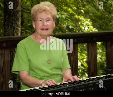 Une femme caucasienne à la retraite (65-70) jouant un clavier à l'extérieur des États-Unis. Banque D'Images