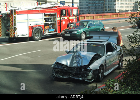 Toujours à l'ouest de Londres avant de voiture après accident de la route d'assister aux pompiers au-delà Banque D'Images