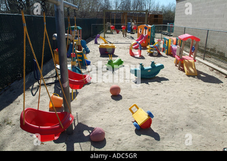 Aire de jeux pour enfants dans un centre de soins de jour avec des jouets en plastique et des balançoires Banque D'Images