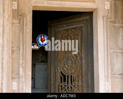 Une vue à travers une porte en fer forgé pour fenêtre en verre teinté du cœur et de l'angel de tomb Banque D'Images