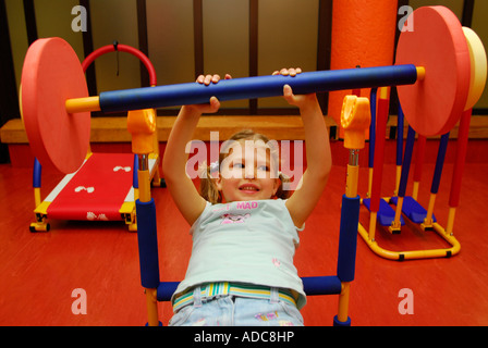 4 ans, fille d'un centre de loisirs, à l'aide de poids en creche, Brixton, London, UK. Banque D'Images