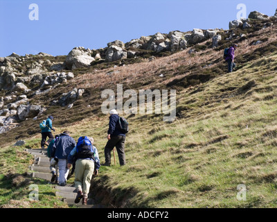 Groupe de randonneurs marcheurs adultes sur l'île d'Anglesey Sentier littoral au nord du Pays de Galles d'Anglesey Llanlleiana Porth UK Banque D'Images