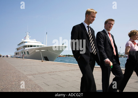 Les gens d'affaires passent devant un yacht de luxe amarré au port de Copenhague Banque D'Images