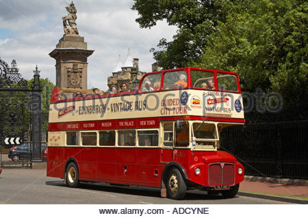 Un opentop bus touristique passant les portes du palais de Holyrood, le Royal Mile Edinburgh SCOTLAND Banque D'Images