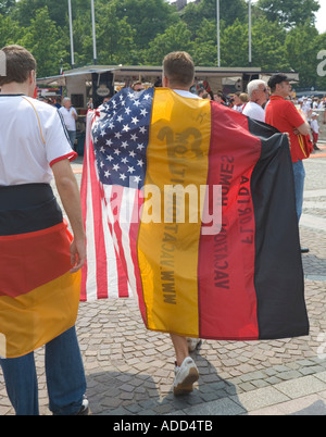 Un supporter de football portant un Allemand et un drapeau américain sur son dos à un événement public Banque D'Images