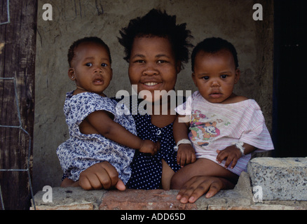 Smiling mother tient ses deux enfants dans la banlieue de Soweto en Afrique du Sud Banque D'Images