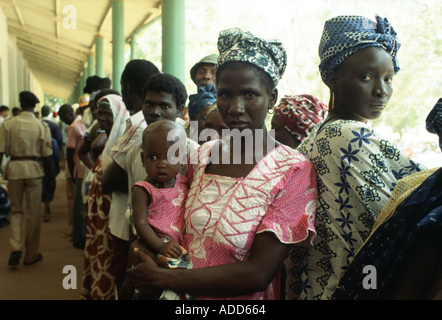 Des femmes faisant la queue avec leurs enfants à l'hôpital rural de basse en Gambie Banque D'Images