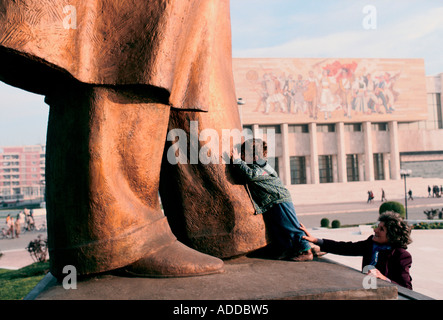 Jeune garçon, encouragé par sa mère, embrassant les pieds de la statue d'Enver Hoxha, le fondateur de l'état communiste, Tirana, 1990 Banque D'Images