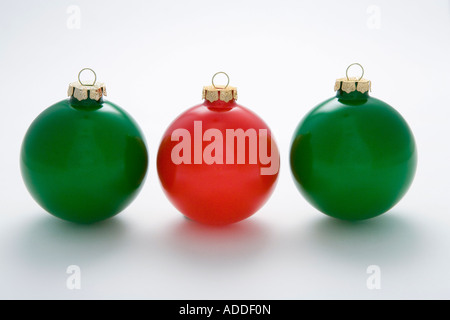 Un arbre de noël ornement rouge ampoule au milieu de deux ampoules vert dans la rangée on white background studio portrait Banque D'Images